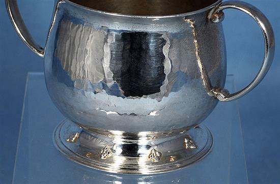 A George V Arts & Crafts silver two handled cup, Width to handles 5”/128mm Height 3”/78mm Weight 7oz/197grms